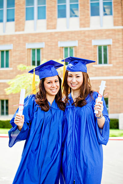 istock two cute graduates with blue cap and gown 174655600