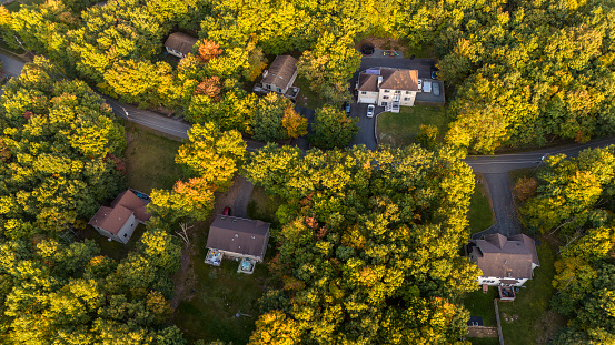 Rural community in Poconos, Pennsylvania. Homes surrounded by the forest during early fall foliage season.