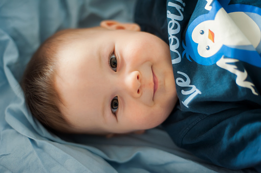 Portrait of cute happy baby boy looking at camera. Joy and happiness concept. Love and family emotion