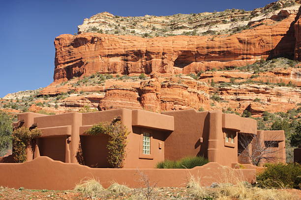 Luxury home in stucco Southwest style architecture with barren arid red rock background - designed to fit in with its desert surrounding.  Sedona, Arizona, 2009.