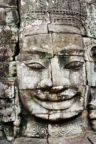 The Giant Face at Angkor Thom "Subject: Vertical close-up of a face carved into interlocking stone bricks at Angkor ThomLocation: Angkor Thom, Cambodia" kannon bosatsu stock pictures, royalty-free photos & images