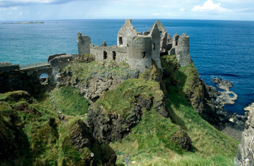 Panoramic view at the ancient Dunluce Castle on the north Antrim coast of Northern Ireland near the Giants Causeway. Horizon over water in the background and the open sea. Ruin on a cliff. XXL