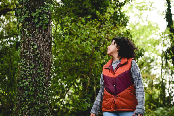 istock woman hiking through a green autumn forest. 1746587974