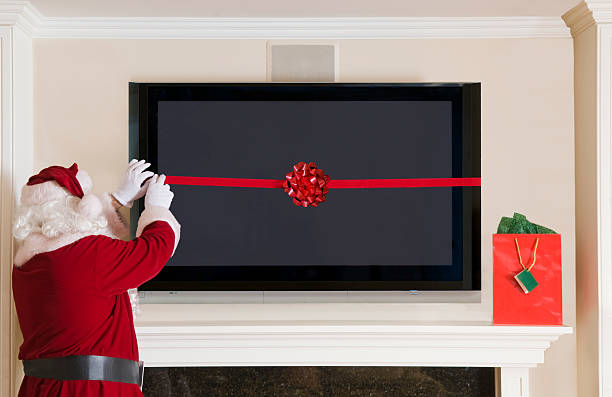 Santa Clause Wrapping a Big Screen TV stock photo
