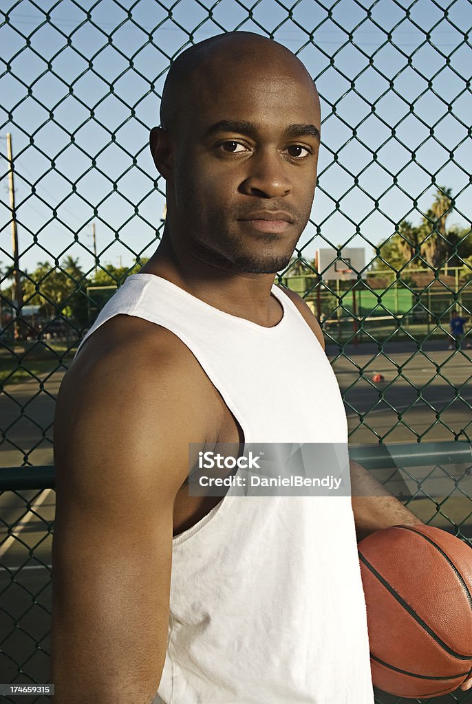 Basketball A young man posing next to basketball court. Active Lifestyle Stock Photo