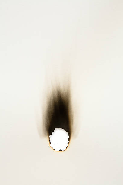 verbrannt loch auf ein blatt papier - anbrennen stock-fotos und bilder