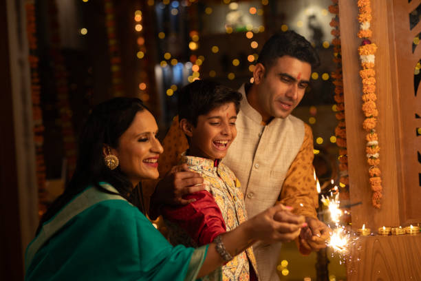 istock Parents with son burning sparklers at home during Diwali 1746600789