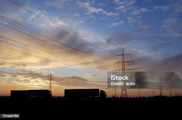 Sulla Strada Di Nuovo Allalba O Due Camion - Fotografie stock e altre immagini di Alba - Crepuscolo - Alba - Crepuscolo, Ambientazione esterna, Arancione