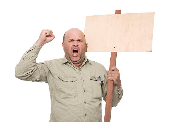 Protesting Worker "An angry worker carrying a protest sign, add own protest." strike protest action stock pictures, royalty-free photos & images