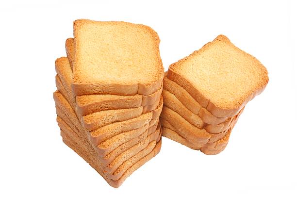 Stack of rusks - isolated on white, Goldener Zwieback a light, dry biscuit or piece of twice-baked bread, especially one prepared for use as baby food zwieback toast stock pictures, royalty-free photos & images