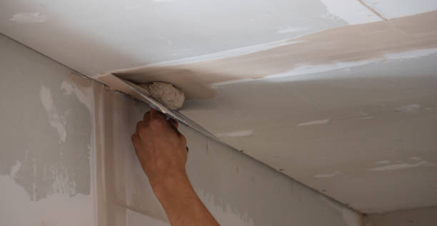 istock A man puts putty on a plasterboard ceiling. Putty for the joints of plasterboard sheets 1746617243