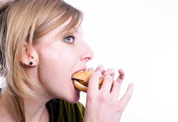istock Young woman eating a burger 174661778
