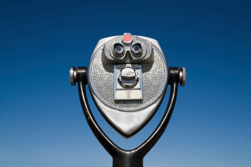 Coin Operated Binoculars set against blue sky background