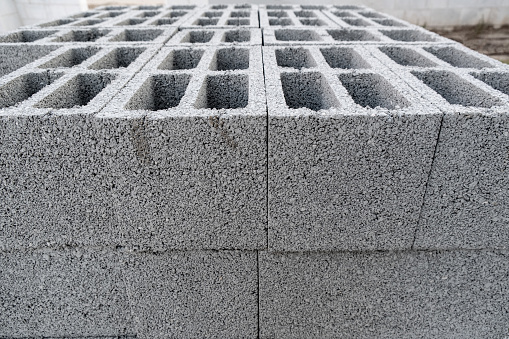 Stack on Pallet of Concrete Cinder Blocks, Grey Uniformed brick Shapes building material. New for use on construction site