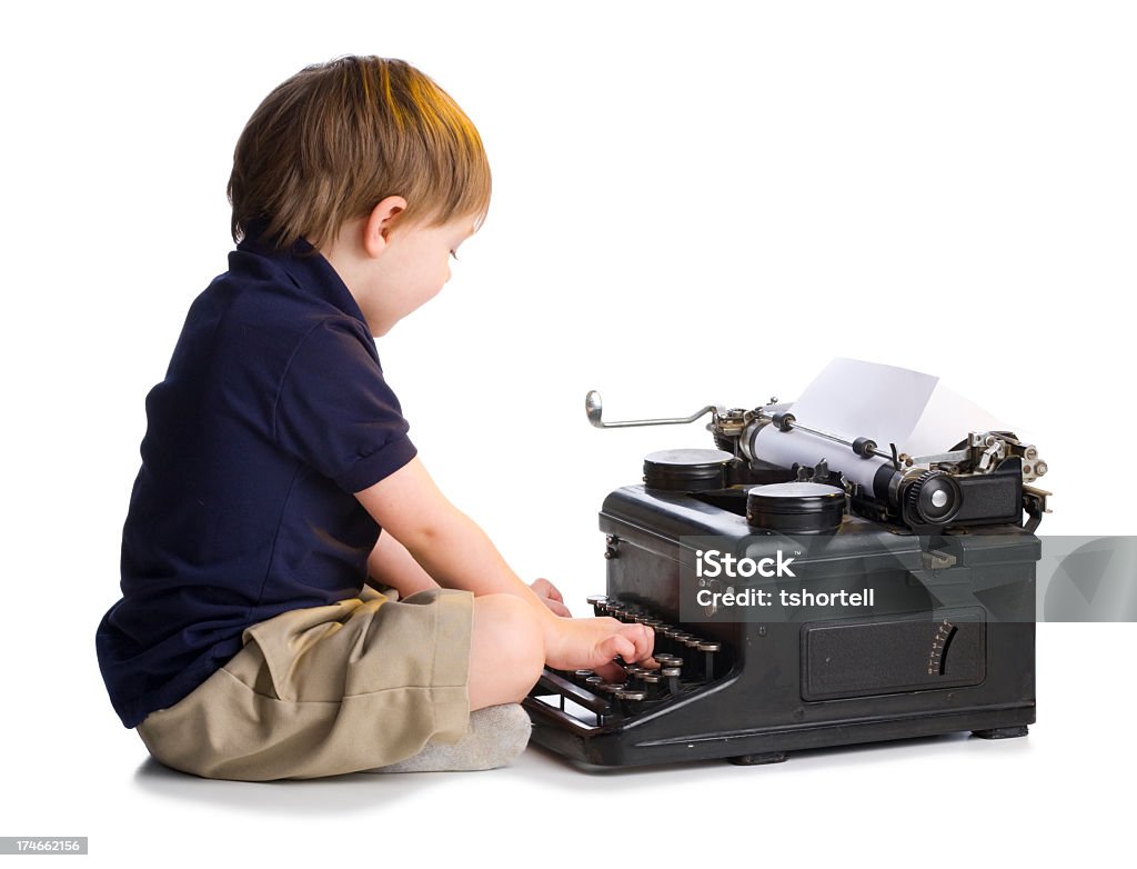 Petit garçon taper sur la vieille machine à écrire - Photo de Antiquités libre de droits