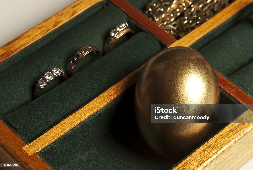 Huevos de oro en un joyero con forro de fieltro verde - Foto de stock de Ahorros libre de derechos