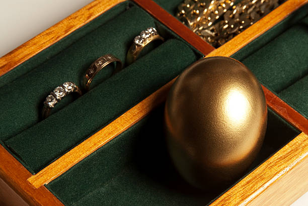 istock Gold Egg in a jewelry box with green felt lining 174662215