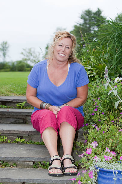 Attractive , smiling young woman lying on steps.