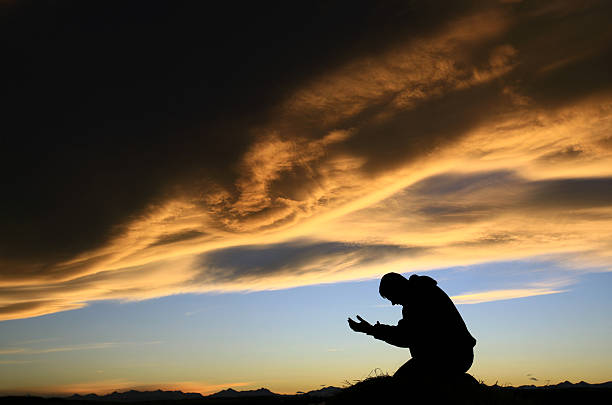 adulto uomo meditare al tramonto - please god foto e immagini stock