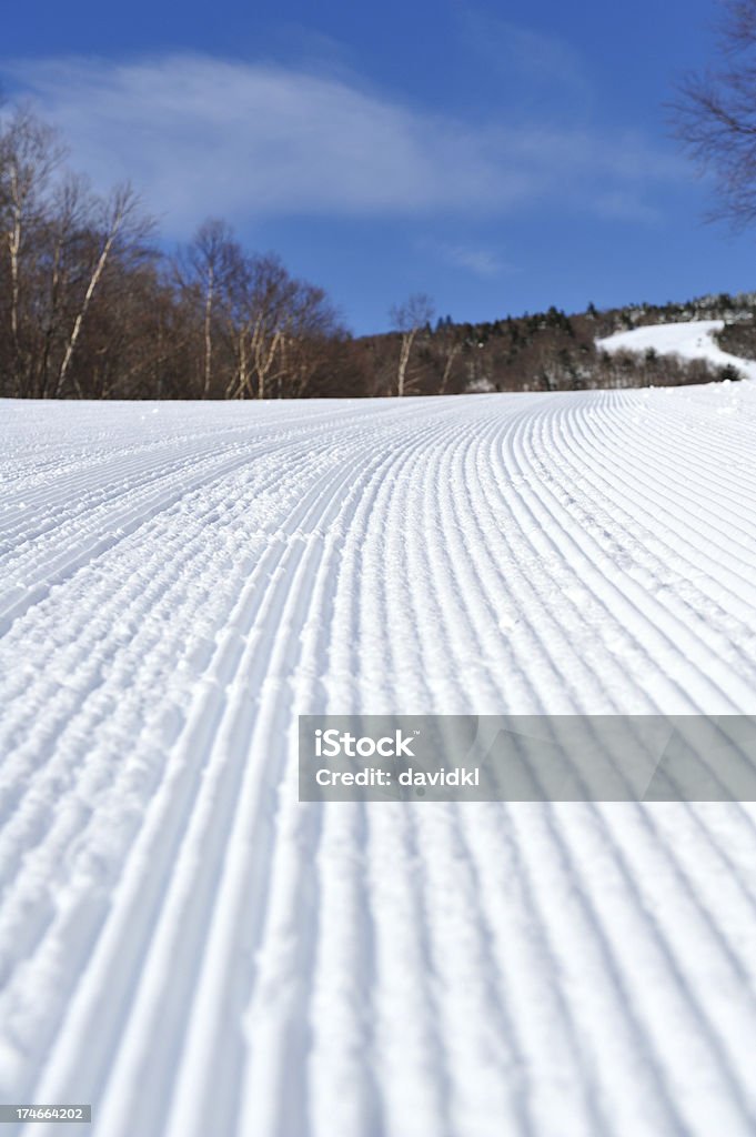 スキースロープした雪をコーデュロイ、ブルースカイ - アウトフォーカスのロイヤリティフリーストックフォト