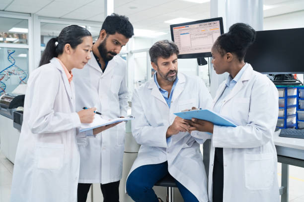 istock Team of biochemists discussing over clipboards at laboratory 1746646267