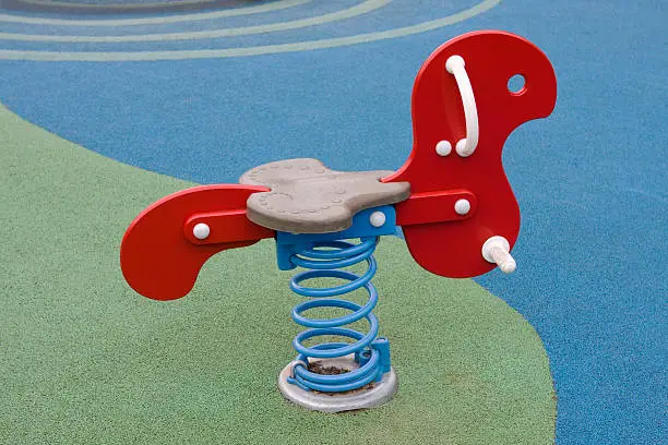 Brand new rocking horse in childrens' adventure playground. Modern minimalist colourful design.