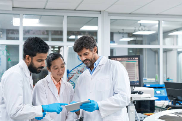 istock Team of biochemists discussing over digital tablet at laboratory 1746646884