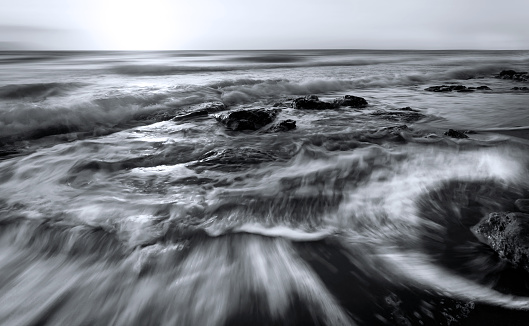 Long exposure of water over rocks on a foggy day.