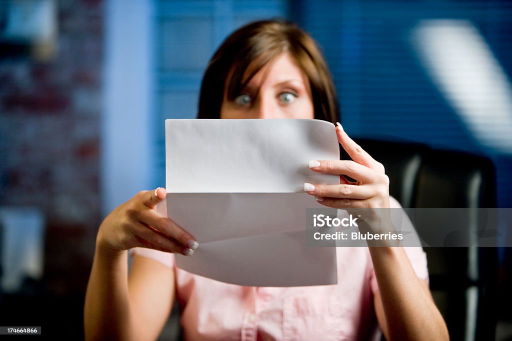 Shocked A woman looking at her mail (letter or bills)  in disbelief, shock!  Financial Bill Stock Photo