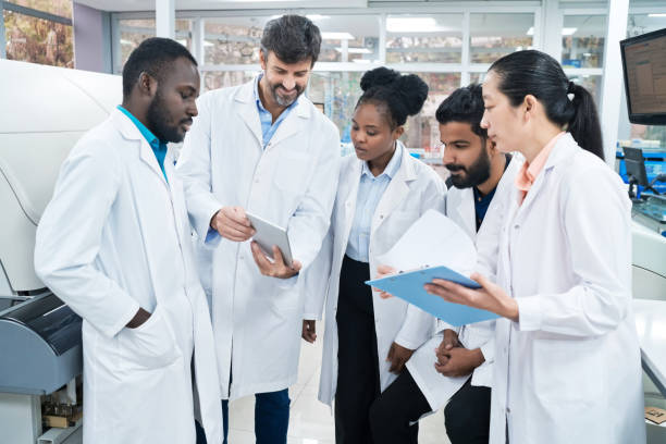 istock Team of scientists discussing over digital tablet and clipboard at laboratory 1746648761