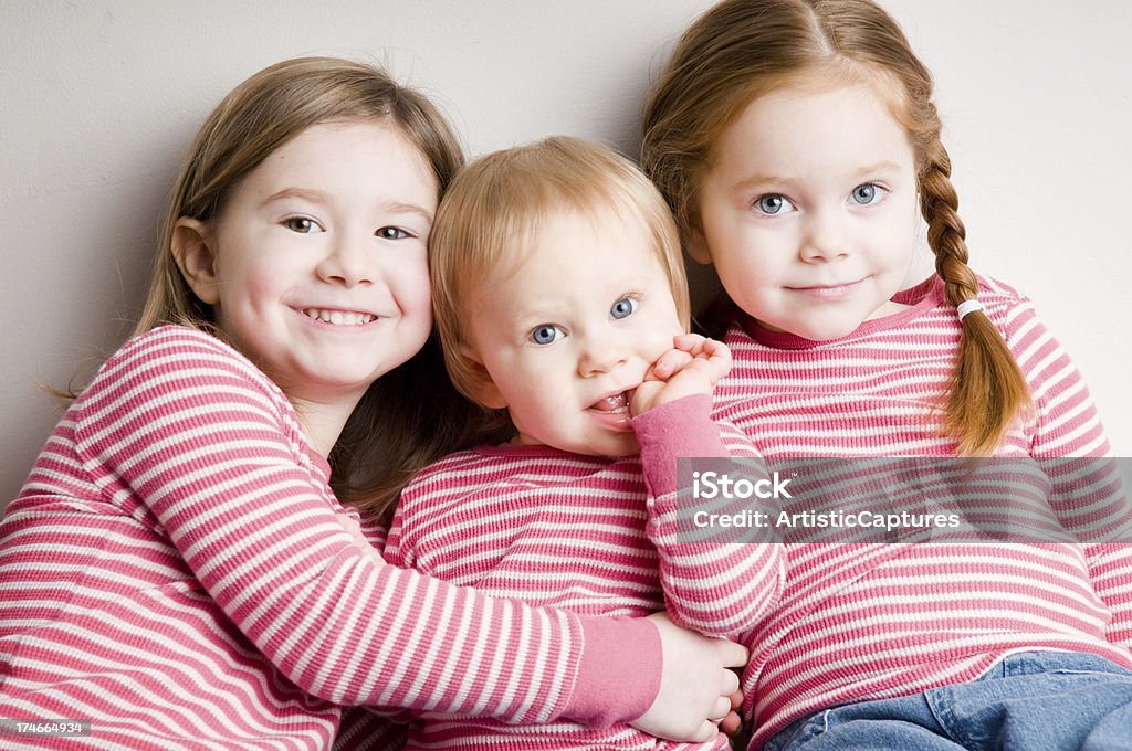 Tres ajustes hermanas Abrazarse juntos - Foto de stock de Hermanos libre de derechos