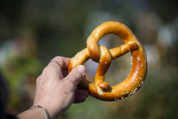 istock bretzel in hand on blurred  background 1746654612