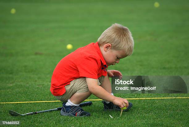 Jovem Rapaz Teeing Uma Bola De Golfe - Fotografias de stock e mais imagens de Golfe - Golfe, Criança, Terreno de Exercício de Golfe