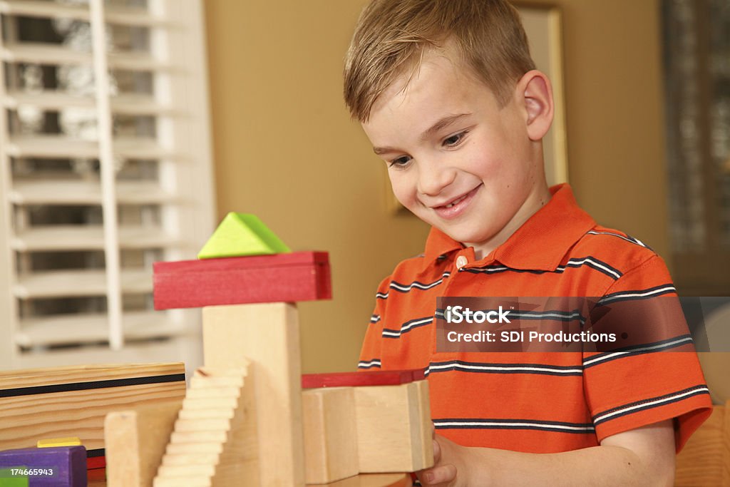 Parvulario niño feliz trabajando en bloques de construcción - Foto de stock de Acabar libre de derechos