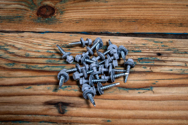 istock Group of roofing screws on a wooden texture background 1746661300