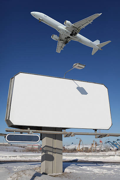 istock Large commercial sign with Airplane passing over 174666173