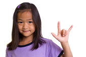 A young girl making an I love you hand sign