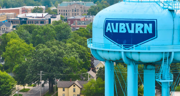 Blue water tower with bold dark blue frame around AUBURN with courthouse in background aerial