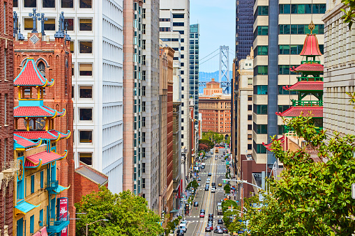 Image of Chinatown buildings with colorful paint and steep road on hill leading to Oakland Bay Bridge