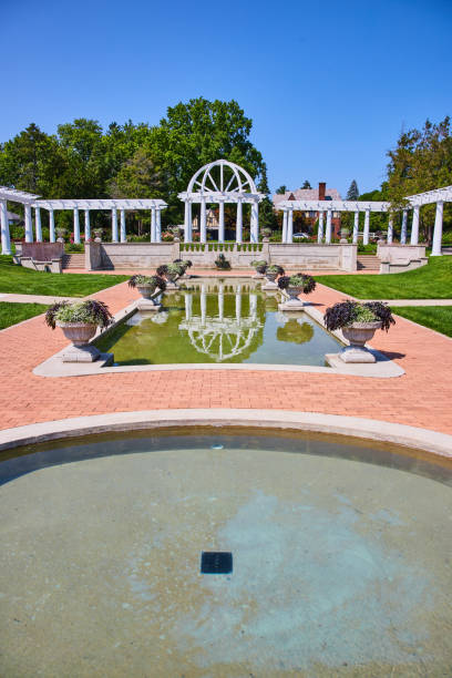 istock Circular pool with rectangle pool ahead with flowerpots and white pergola and trellises 1746685260
