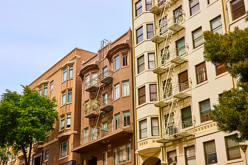 Image of Close together apartment buildings with fire escapes in San Francisco with earthy color tones