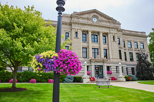 Image of Colorful flowers on light post with wide view of Dekalb County courthouse