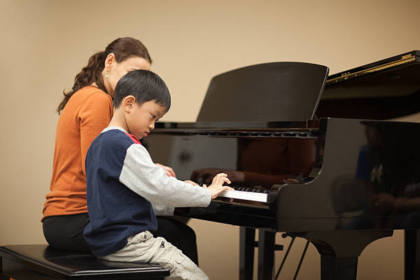 istock Child and piano teacher 174669860