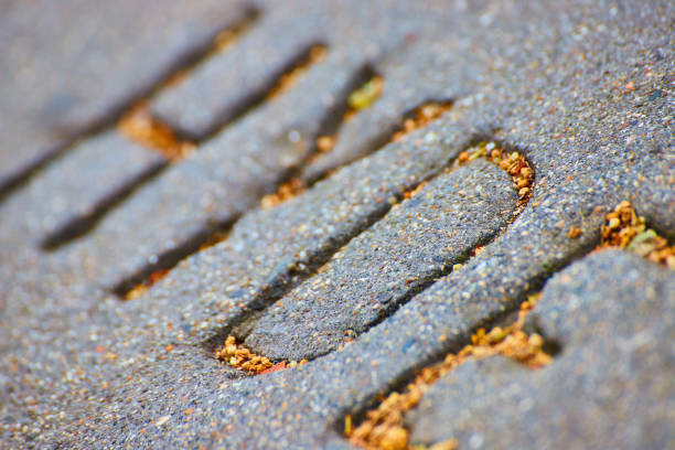 The streets in some part of New York are very worn with plenty of potholes and a mixture of asphalt and cobblestones. The photograph is taken in the Lower Manhattan, New York.
