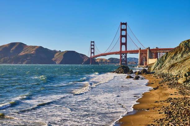 istock Golden Gate Bridge viewed from sandy beach with waves crashing against rocks 1746712567