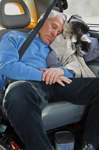 cansado homem idoso dormir no carro com cinto de segurança - old men car vertical imagens e fotografias de stock