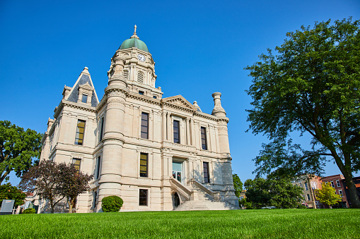 Image of Green lawn and blue sky day with front view of Whitley County Courthouse entrance
