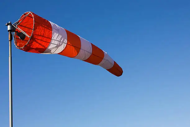 A windsock isolated against a clear blue sky.