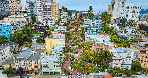 Image of Low aerial Lombard Street with houses and cars and view of city