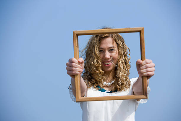 Girl on beach holding picture frame. Taken with Canon 1Ds MarkIII